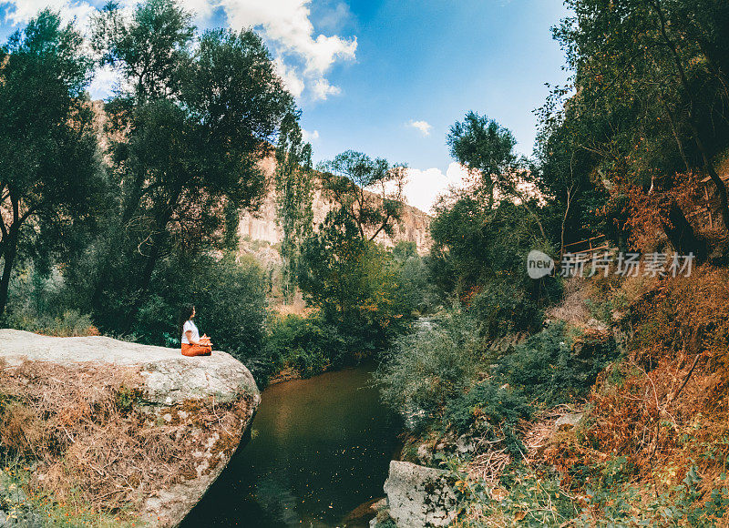 一个年轻的女孩正在土耳其Aksaray Peristrema山谷的Ihlara山谷冥想，做瑜伽